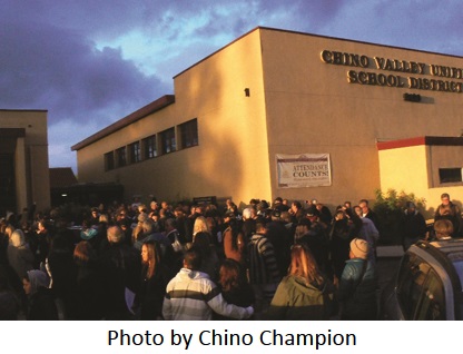 Crowd outside Chino Valley School District with caption